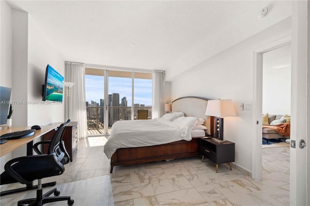 bedroom featuring expansive windows, access to outside, and a textured ceiling