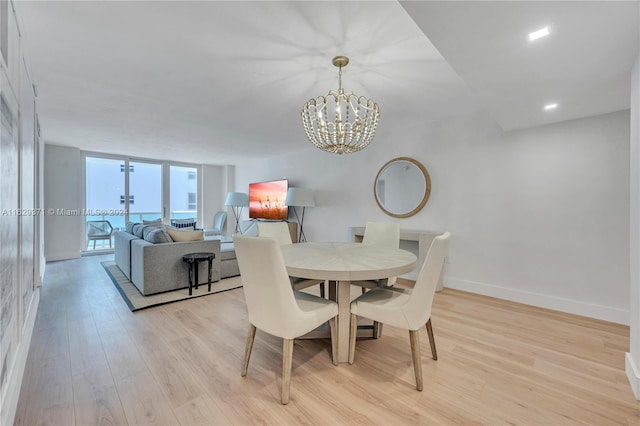 dining space with expansive windows, a notable chandelier, and light hardwood / wood-style floors