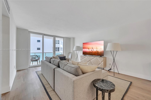 living room with light wood-type flooring and floor to ceiling windows