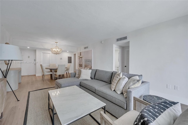 living room featuring a chandelier and light hardwood / wood-style floors