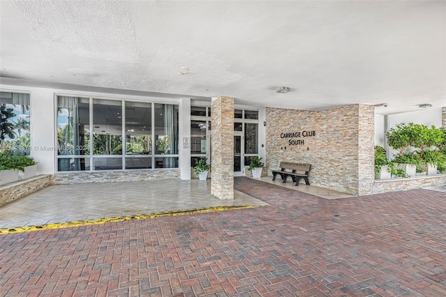 view of exterior entry with a patio area