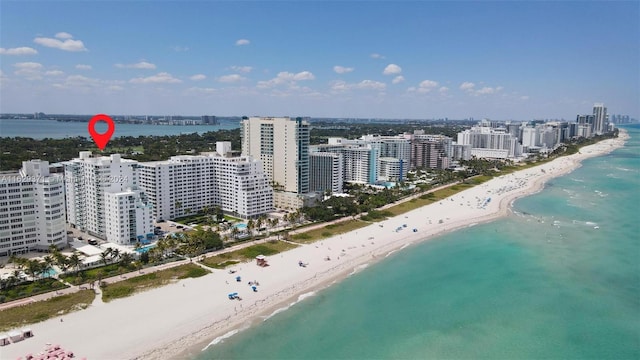 bird's eye view with a water view and a beach view