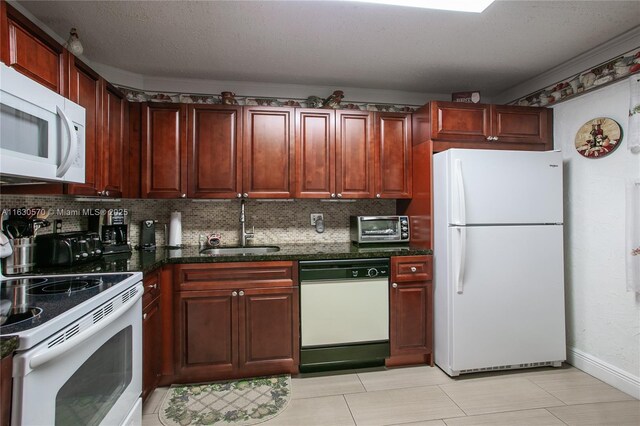 kitchen with white appliances, a textured ceiling, tasteful backsplash, sink, and dark stone countertops