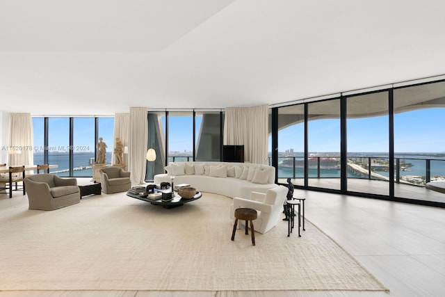 living room featuring plenty of natural light, floor to ceiling windows, and a water view