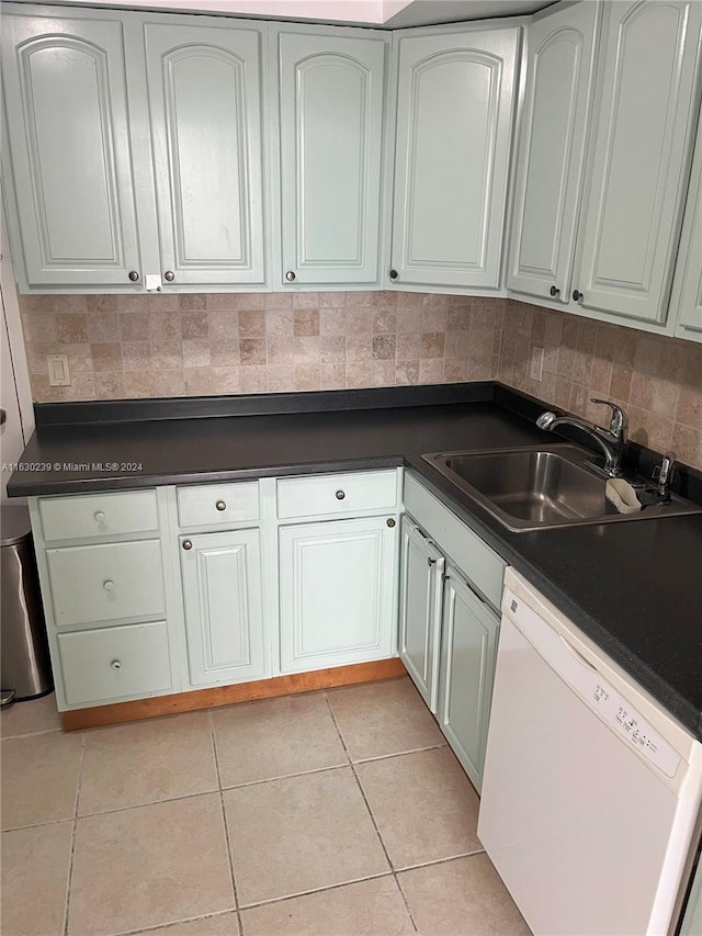 kitchen featuring light tile patterned flooring, sink, backsplash, and white dishwasher