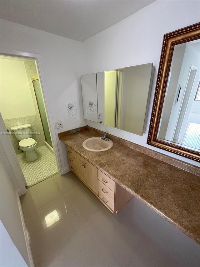 bathroom featuring tile patterned flooring, toilet, and vanity