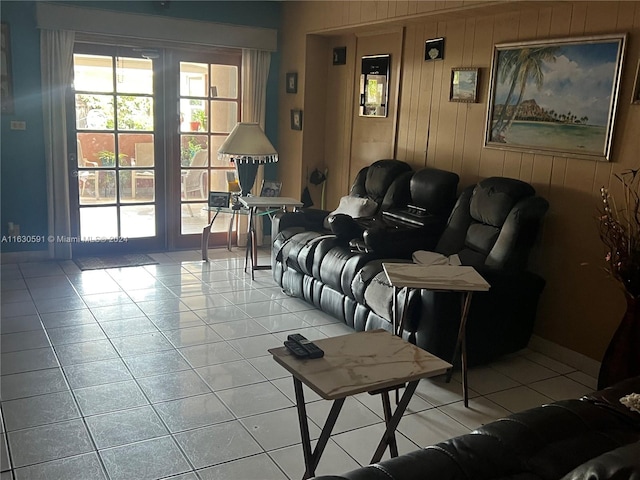 living room featuring wooden walls and light tile patterned floors