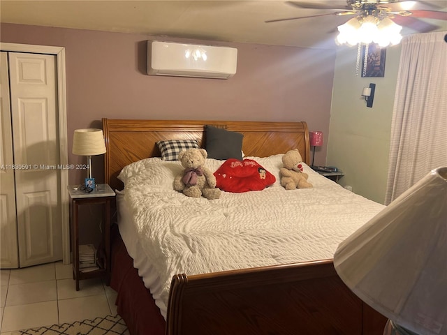 bedroom with light tile patterned flooring, a wall mounted air conditioner, a closet, and ceiling fan