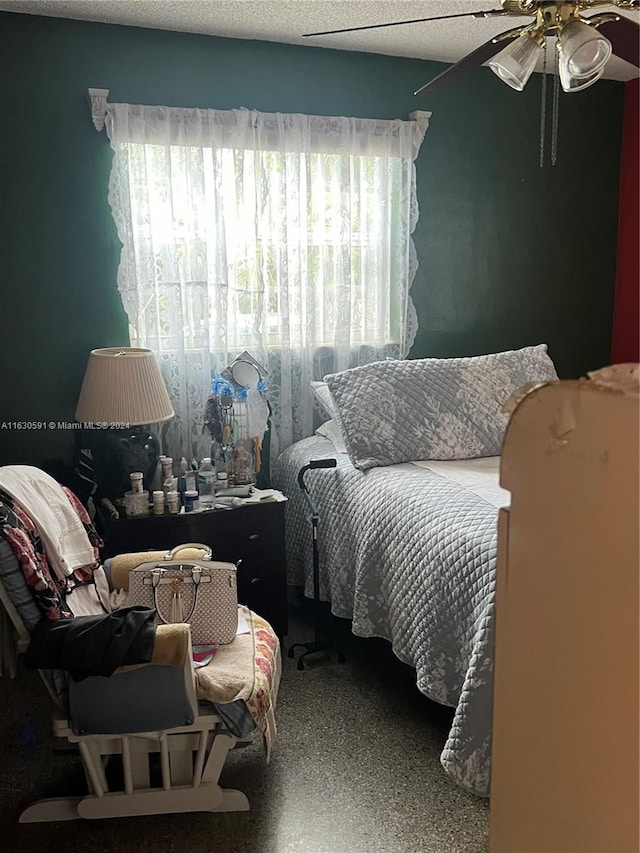 bedroom featuring multiple windows, a textured ceiling, and ceiling fan