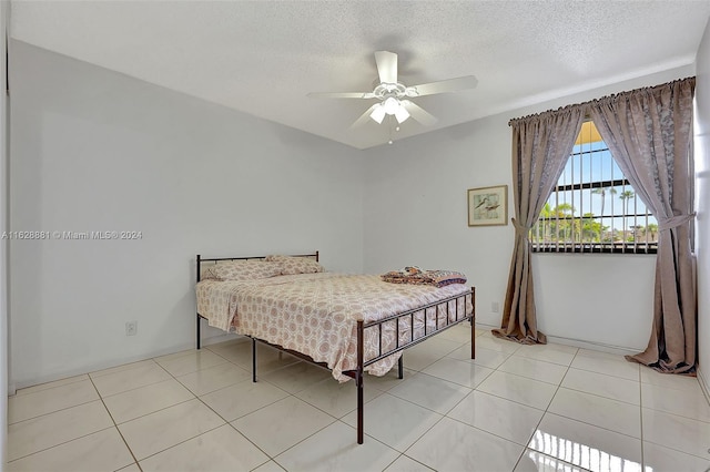 tiled bedroom with ceiling fan and a textured ceiling