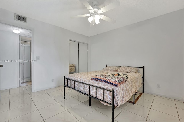 bedroom featuring ceiling fan, a closet, and light tile patterned floors