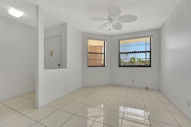 unfurnished room featuring ceiling fan, a textured ceiling, and light tile patterned floors