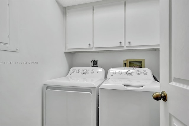 laundry room with cabinets and washer and dryer