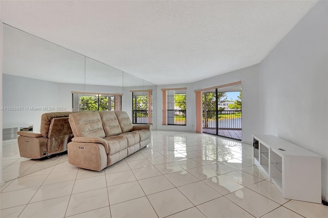 living room featuring light tile patterned flooring, a healthy amount of sunlight, and a textured ceiling