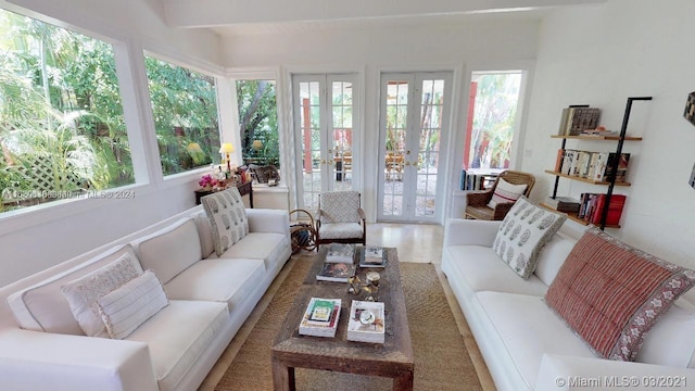 sunroom featuring beamed ceiling and french doors