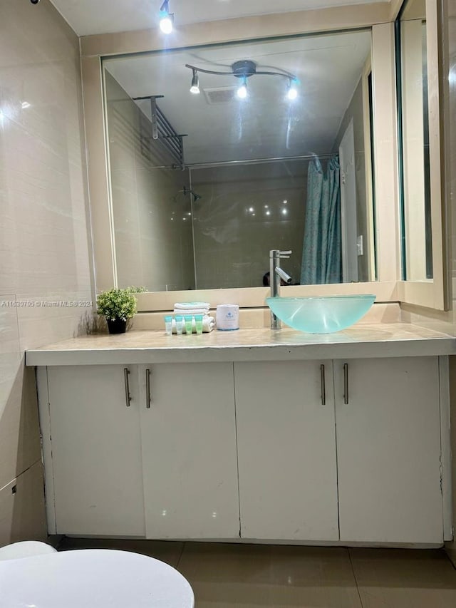 bathroom featuring tile patterned floors, toilet, vanity, and a shower with curtain