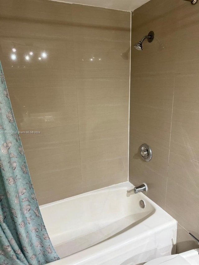 bathroom with tile walls and shower / tub combo