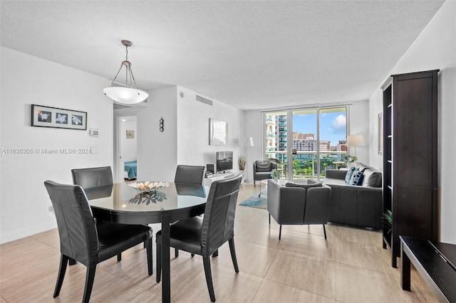 dining space with a wall of windows and a textured ceiling