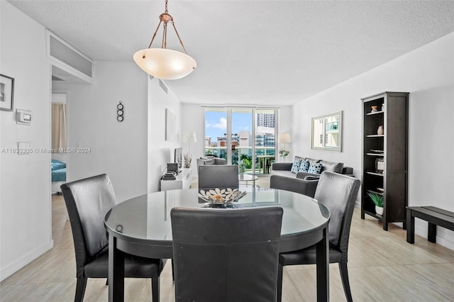 dining area with a textured ceiling and floor to ceiling windows