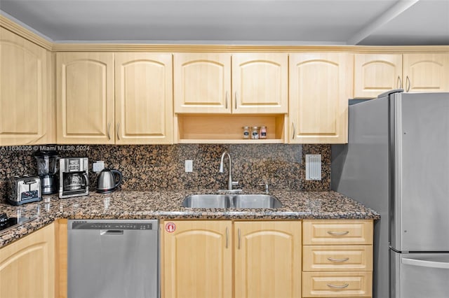 kitchen with light brown cabinetry, sink, tasteful backsplash, and stainless steel appliances