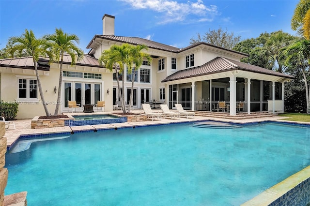 rear view of property with a patio, a sunroom, and french doors