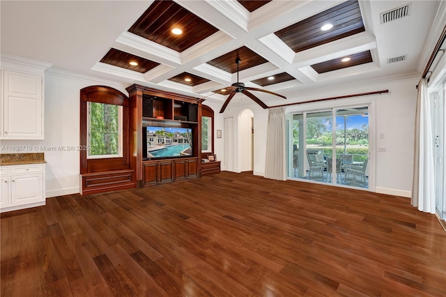 unfurnished living room with dark wood-type flooring, ceiling fan, coffered ceiling, ornamental molding, and beamed ceiling