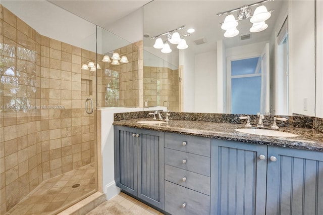 bathroom with walk in shower, vanity, and tile patterned flooring