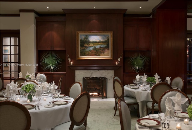 dining area featuring crown molding, carpet flooring, and a premium fireplace