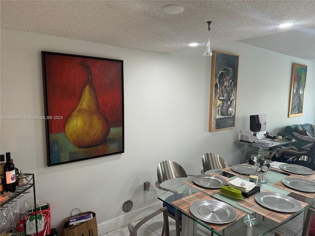 dining space featuring tile patterned flooring and a textured ceiling