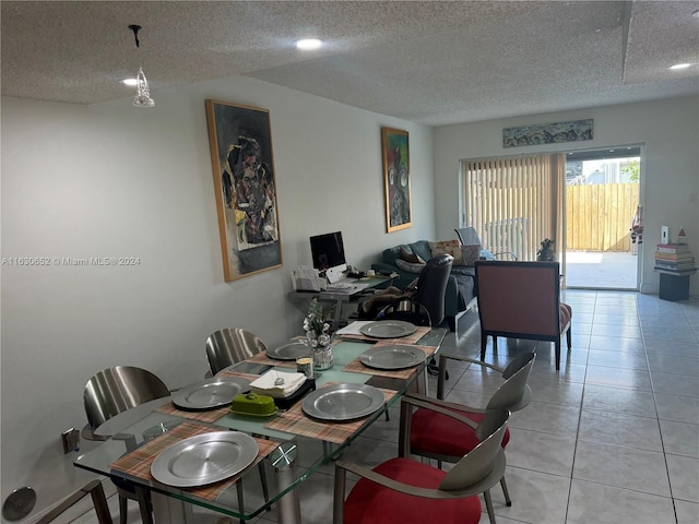 dining space featuring light tile patterned floors and a textured ceiling