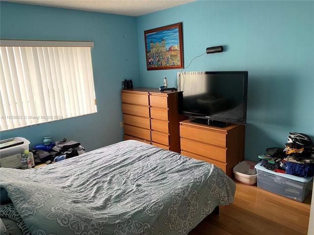 bedroom featuring a textured ceiling and hardwood / wood-style flooring