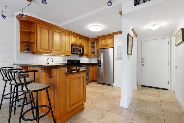 kitchen featuring a peninsula, brown cabinetry, and stainless steel appliances