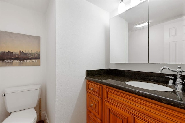 half bathroom with toilet and vanity