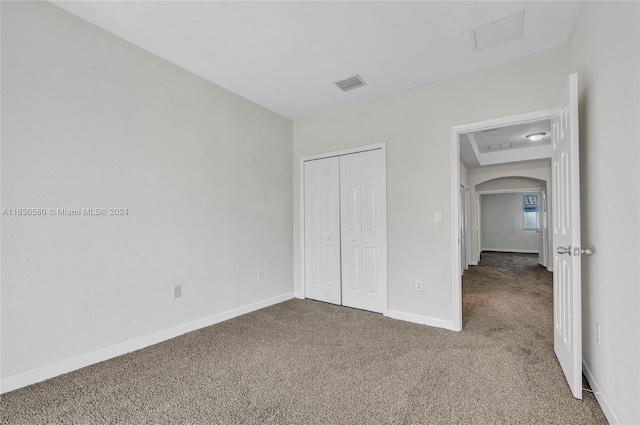 unfurnished bedroom featuring carpet and a closet