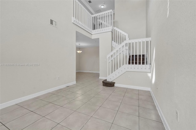 tiled spare room with a high ceiling