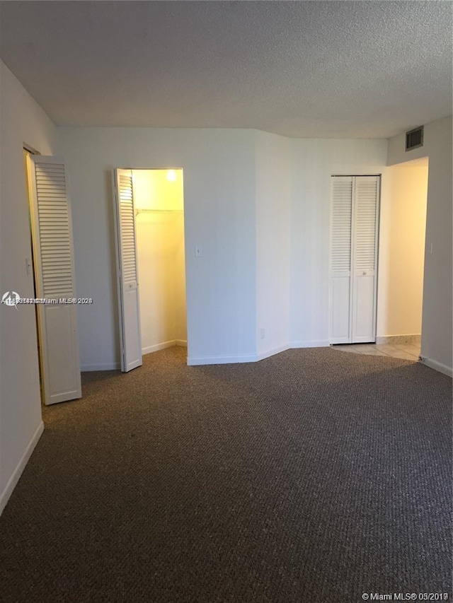 empty room featuring a textured ceiling and carpet flooring