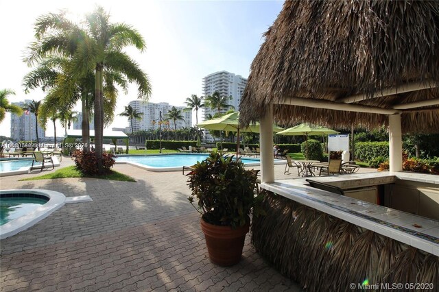 view of pool with a hot tub and a patio