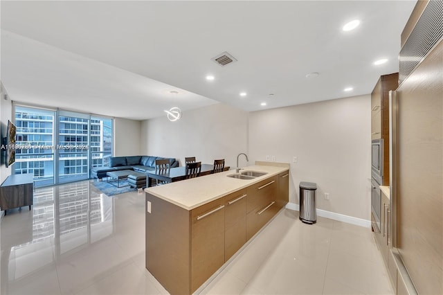 kitchen featuring floor to ceiling windows, sink, light tile patterned flooring, and kitchen peninsula