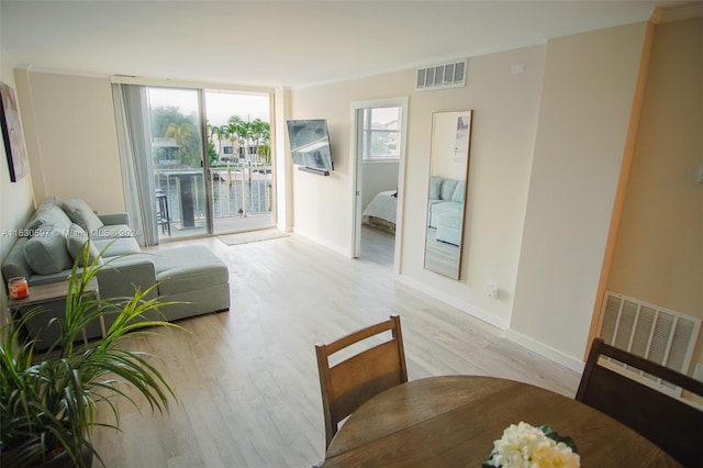 living room featuring ornamental molding and light wood-type flooring