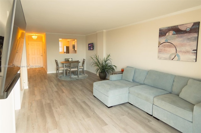 living room with ornamental molding and light hardwood / wood-style floors