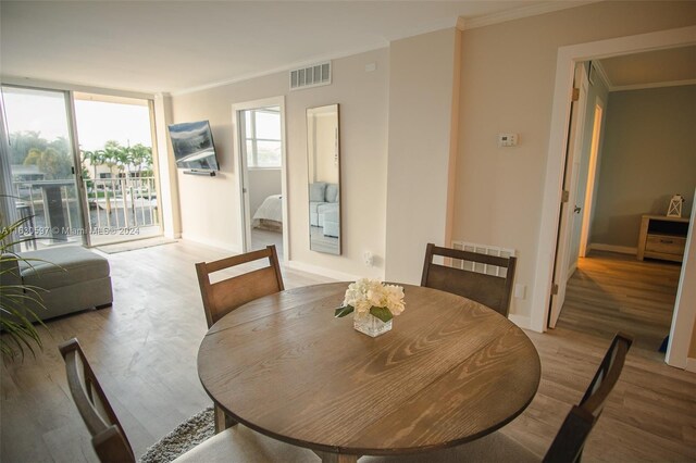 dining room with ornamental molding and wood-type flooring