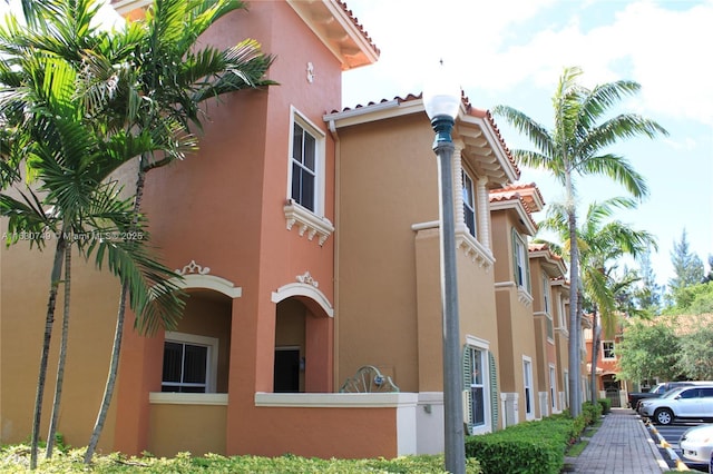 view of building exterior featuring uncovered parking and a fenced front yard