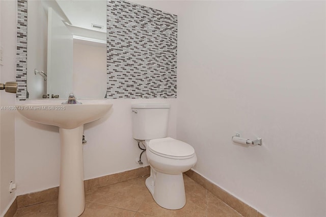 half bath featuring visible vents, tile patterned flooring, toilet, and baseboards