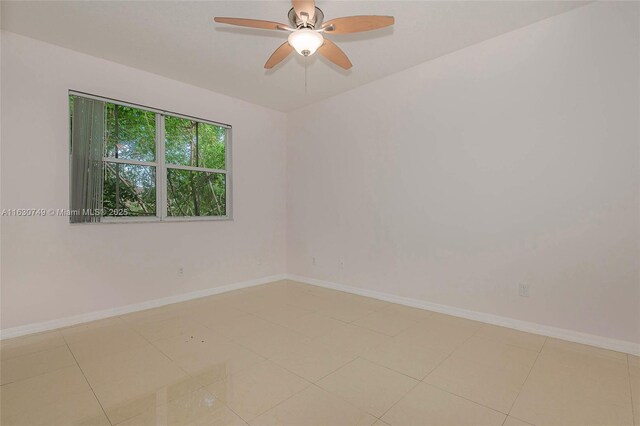 tiled spare room featuring ceiling fan