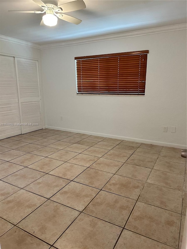 spare room with light tile patterned floors, ceiling fan, and ornamental molding