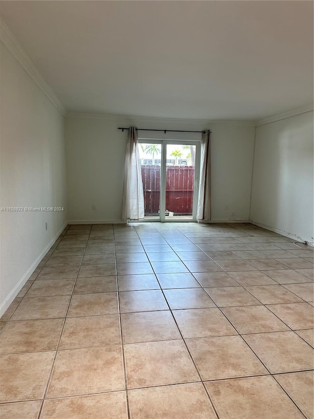 spare room with ornamental molding and light tile patterned flooring