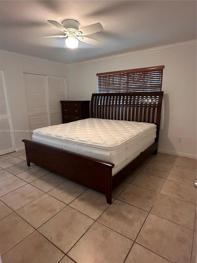 tiled bedroom featuring ceiling fan, ornamental molding, and a closet