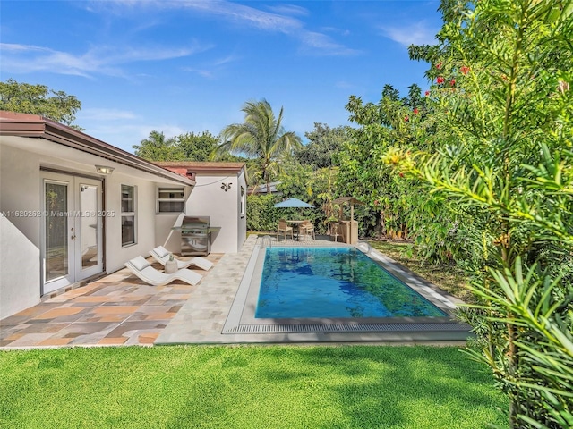 view of pool featuring french doors, a patio area, and a grill