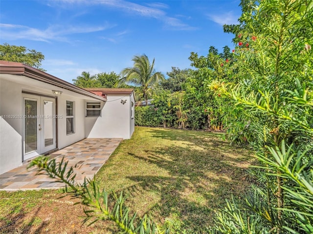 view of yard featuring french doors and a patio