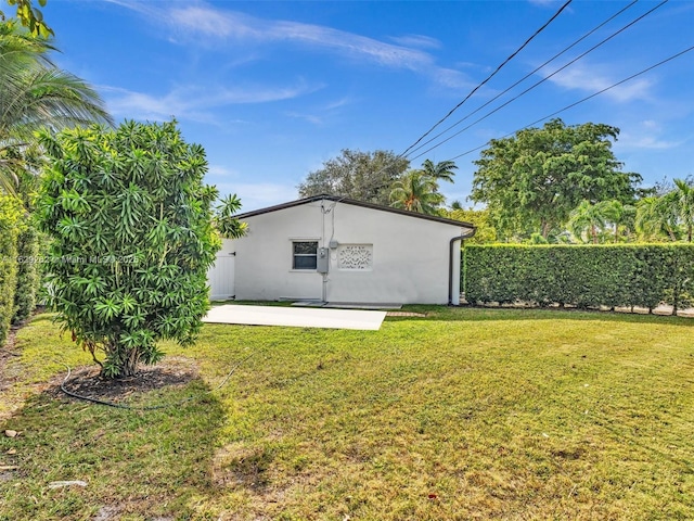 back of property featuring a patio area and a yard